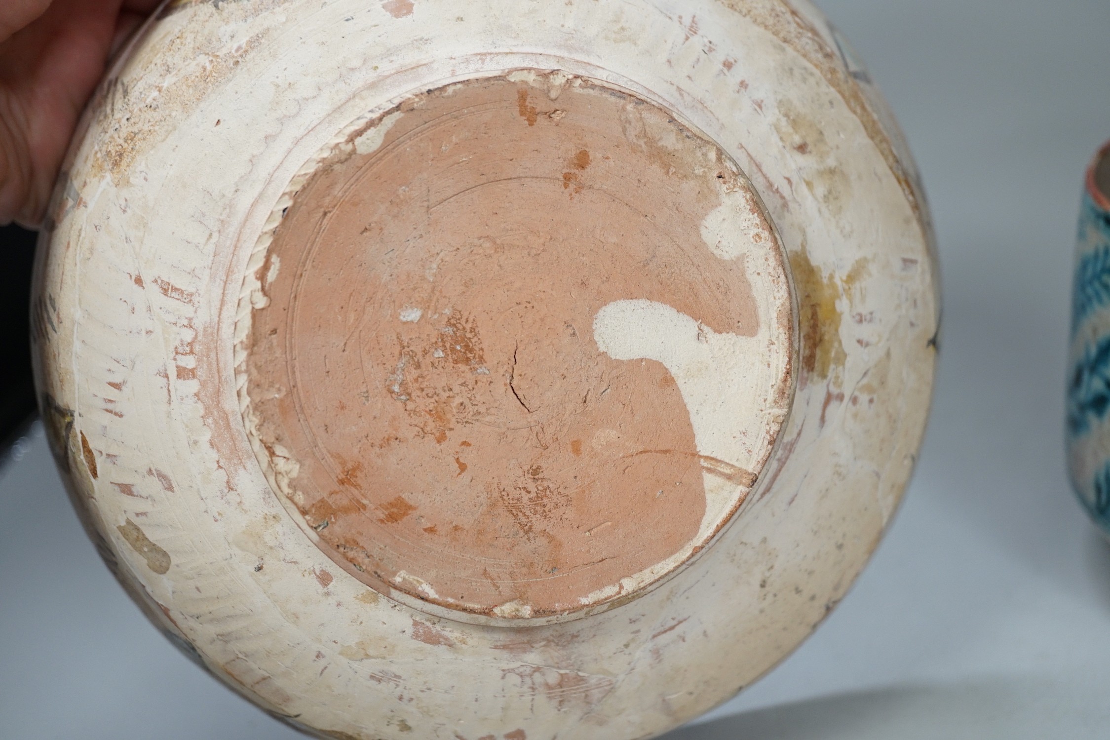 An Islamic Persian bowl with turquoise blue leaf design, 15cm diameter, together with a section of an Islamic tile, and another Islamic bowl, possibly Kashan. Tallest 11cm